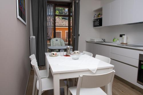 a white kitchen with a white table and chairs at Casa Valentin in Monforte dʼAlba