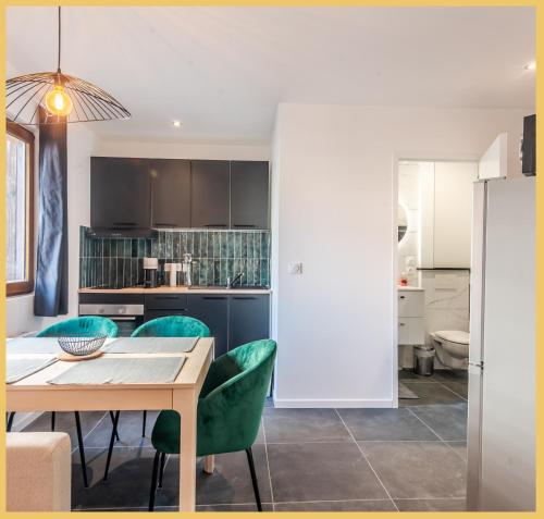 une cuisine et une salle à manger avec une table et des chaises vertes dans l'établissement Appartement T2 I Unique I Cluses, à Cluses