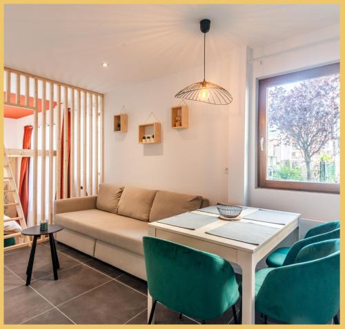 un salon avec un canapé, une table et des chaises dans l'établissement Appartement T2 I Unique I Cluses, à Cluses