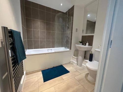 a bathroom with a tub and a toilet and a sink at Stylish 3 beds North Greenwich 02 Arena Apartment in London