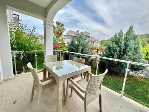 a white table and chairs on a porch with a view at Legend Apartments in Fethiye