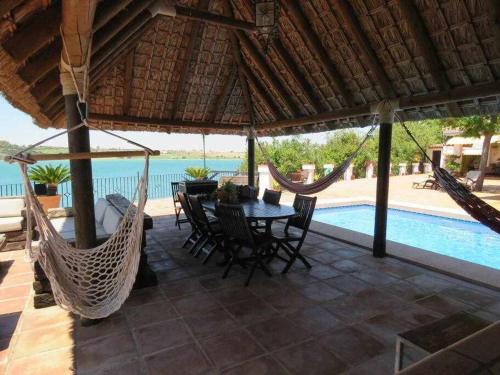 a patio with a table and chairs and a pool at Espectacular casa con embarcadero in Arcos de la Frontera