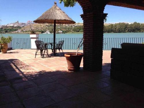 a patio with an umbrella and a table and chairs at Espectacular casa con embarcadero in Arcos de la Frontera