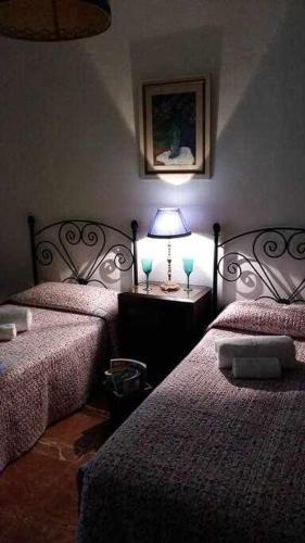 a bedroom with two beds and a lamp on a table at Espectacular casa con embarcadero in Arcos de la Frontera