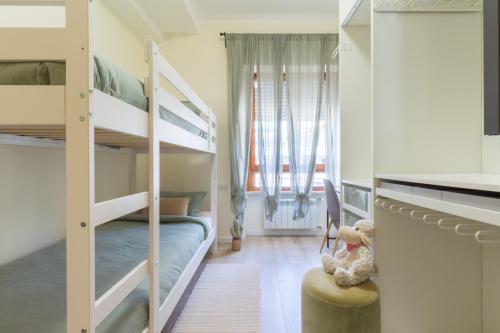 a bedroom with bunk beds and a teddy bear sitting on a stool at Sonnino House in Cagliari