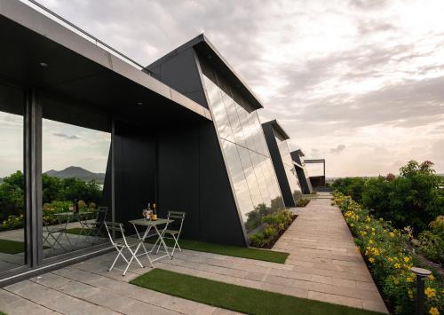 a house with black walls and a patio with a table and chairs at Beyond by Sula in Nashik