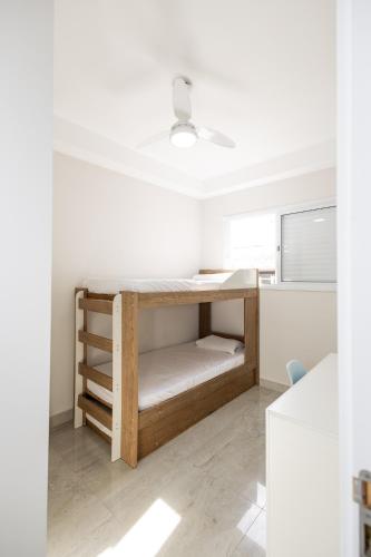 a small room with a bed and a desk at Itanhaém Praia & Mar in Itanhaém