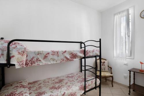 um quarto com 2 beliches e uma cadeira em Home Gilda em Imperia