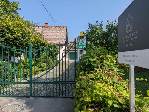 un cancello con un cartello di fronte a un edificio di HoMEMADE Bed and breakfast a Lubiana