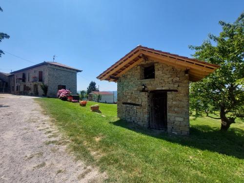 un pequeño edificio de piedra al lado de una carretera en Agriturismo La Margherita, en San Giorgio Scarampi