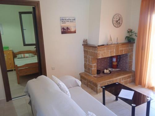 a living room with a couch and a fireplace at Mary's House in Vourvourou