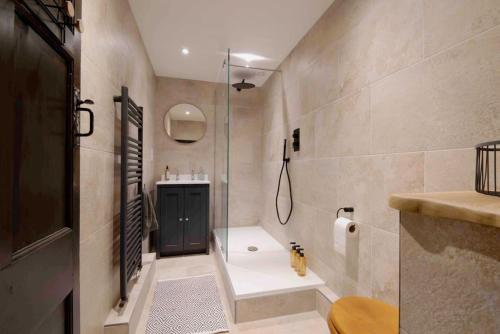 ein Bad mit einer Dusche und einem Waschbecken in der Unterkunft Characterful apartment in the heart of Petworth in Petworth