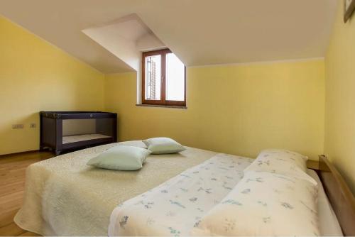 a bedroom with two beds and a window at Apartment Petar in Begi in Vrsar