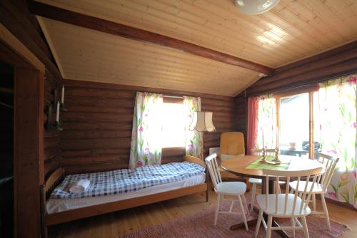 Pokój z łóżkiem, stołem i krzesłami w obiekcie Pukinsaaren Camping w mieście Kristinestad