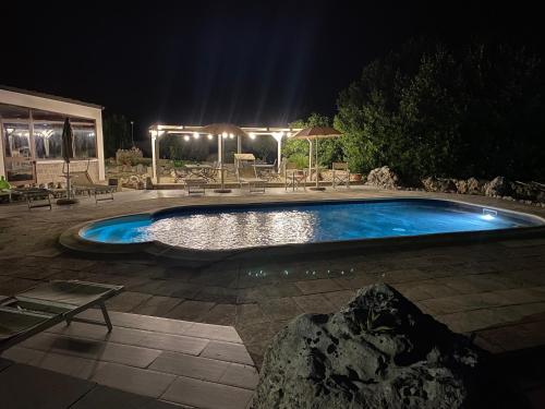 una piscina en un patio por la noche en Agriturismo Masseria Saittole, en Carpignano Salentino