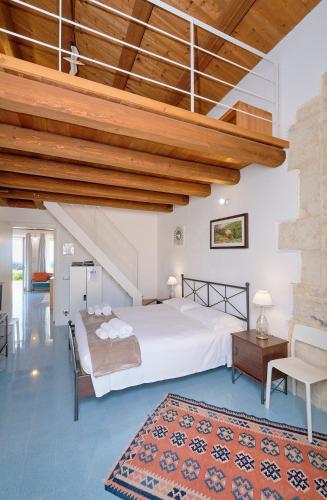 a bedroom with a large bed and a wooden ceiling at Petrantica in Marina di Ragusa