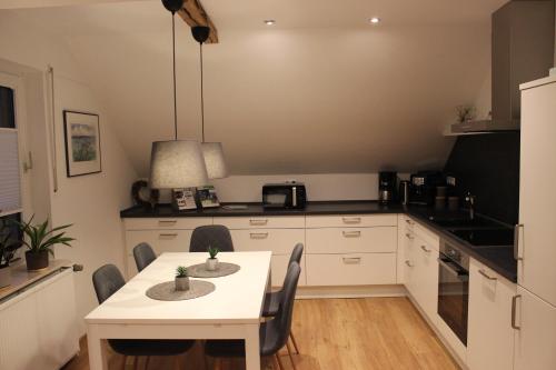 a kitchen with a white table and chairs in it at Ferienwohnung Lorenz´ Traumzeit - Emsland in Dörpen
