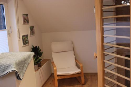 a white chair sitting in a room with a window at Ferienwohnung Lorenz´ Traumzeit - Emsland in Dörpen