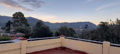 a view of the mountains from the balcony of a house at Shanthi Villa in Coonoor
