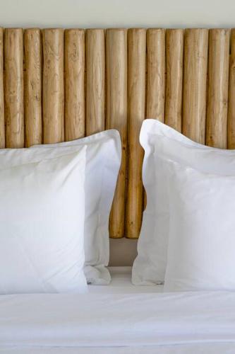 two white pillows sitting on a bed in front of a wall at Lyra Sunset Suite in Kampos Paros