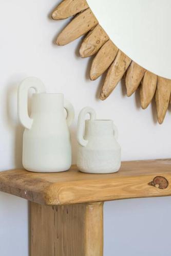 two white vases sitting on a wooden shelf at Lyra Sunset Suite in Kampos Paros