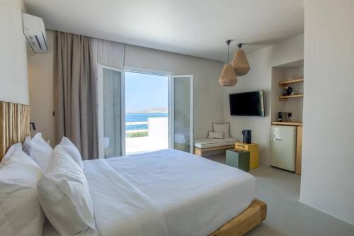 una camera con un grande letto e vista sull'oceano di Lyra Sunset Suite a Kampos Paros