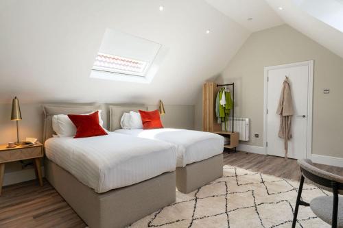 a bedroom with two beds with red pillows at Wellington Place I Your Apartment in Bristol