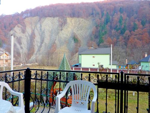 two chairs on a balcony with a view of a mountain at Sadyba Bilya Richky in Yaremche