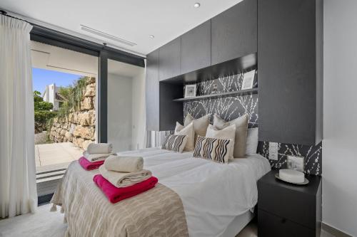 um quarto com uma grande cama branca e uma janela em Villa Alejandra - Benahavis em Estepona