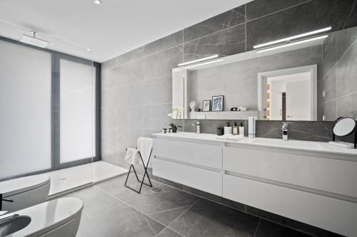 uma casa de banho com uma banheira, um lavatório e um espelho. em Villa Alejandra - Benahavis em Estepona