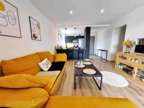 un salon avec un canapé jaune et une table dans l'établissement Charmant T3 à Porticcio, à Porticcio