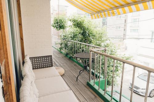 uma varanda com uma mesa e algumas plantas em Hongdae Luxury Private Single House with Big Open Balcony Perfect for a Family & Big Group 3BR, 5QB & 1SB, 2Toilet em Seul
