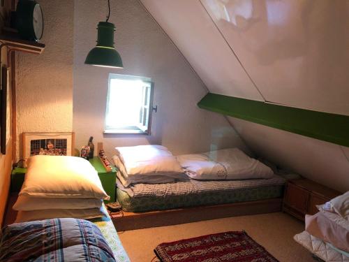 PaleyにあるMaison de Villemaréchalのベッド2台と窓が備わる屋根裏部屋です。
