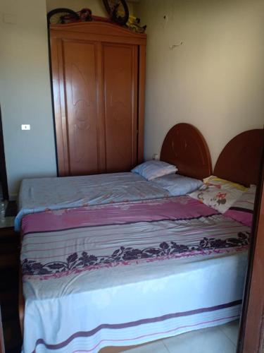 uma cama com uma cabeceira em madeira num quarto em شاليهات للايجار بمارينا 4،5،6، em El Alamein