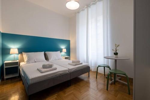 a bedroom with a large bed with a blue wall at Mia Rooms - Zimmer mit Privatbad Bozen Zentrum01 in Bolzano