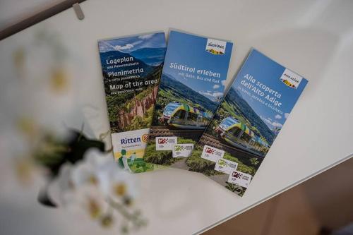 three brochures on top of a table at Mia Rooms - Zimmer mit Privatbad Bozen Zentrum01 in Bolzano