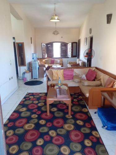 uma sala de estar com um sofá e uma mesa num tapete em شاليهات للايجار بمارينا 4،5،6، em El Alamein