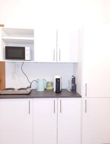 a kitchen counter with white cabinets and a microwave at Mia Rooms - Zimmer mit Privatbad Bozen Zentrum01 in Bolzano