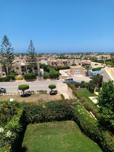 uma vista para um parque com arbustos e um parque de estacionamento em شاليهات للايجار بمارينا 4،5،6، em El Alamein