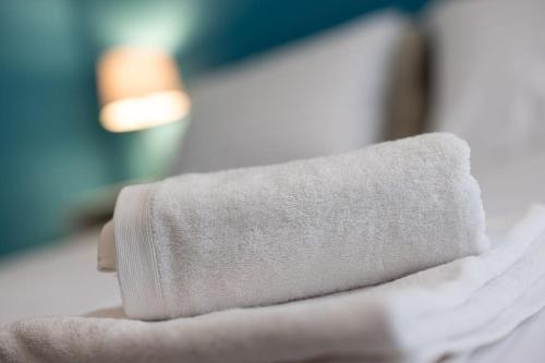 a rolled up towel sitting on top of a bed at Mia Rooms - Zimmer mit Privatbad Bozen Zentrum01 in Bolzano