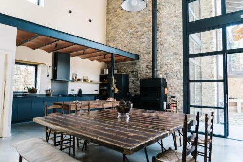 eine offene Küche und ein Esszimmer mit einem großen Holztisch in der Unterkunft Mas Cal Rus in Alp