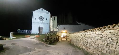 a white church with a clock tower at night at B&B dell'Osteria in SantʼAnatolia di Narco