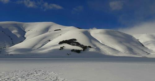 a mountain covered in snow on top of a field at B&B dell'Osteria in SantʼAnatolia di Narco