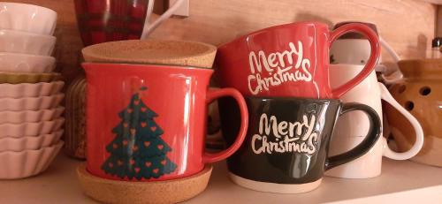 two christmas mugs sitting on top of a counter at B&B dell'Osteria in SantʼAnatolia di Narco