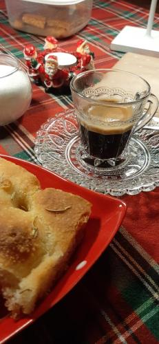 a red plate with a piece of pie and a cup of coffee at B&B dell'Osteria in SantʼAnatolia di Narco