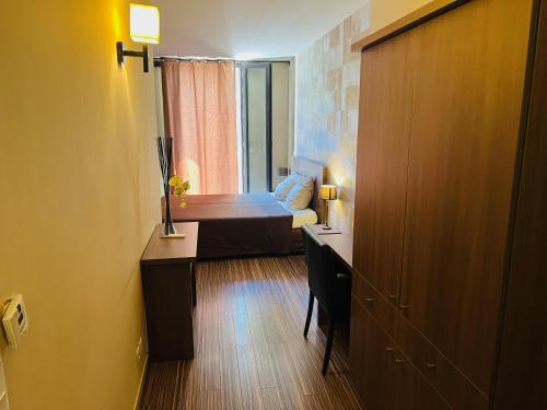 a room with a desk and a room with a bed at L'HOTEL DE LA BOURSE à BAGNOLS-SUR-CEZE in Bagnols-sur-Cèze
