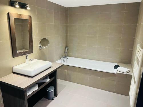 a bathroom with a sink and a bath tub at L'HOTEL DE LA BOURSE à BAGNOLS-SUR-CEZE in Bagnols-sur-Cèze