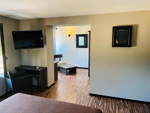 a hotel room with a large door leading to a living room at L'HOTEL DE LA BOURSE à BAGNOLS-SUR-CEZE in Bagnols-sur-Cèze