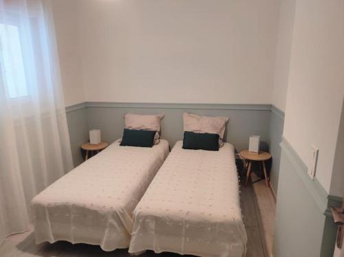 - 2 lits dans une petite chambre avec 2 tables de chevet dans l'établissement Magnifique Villa aux Oliviers trentenaires, à Mougins