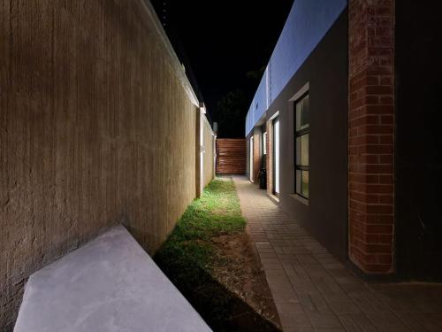 a dark alley with a bench next to a building at East Park Inn in Polokwane